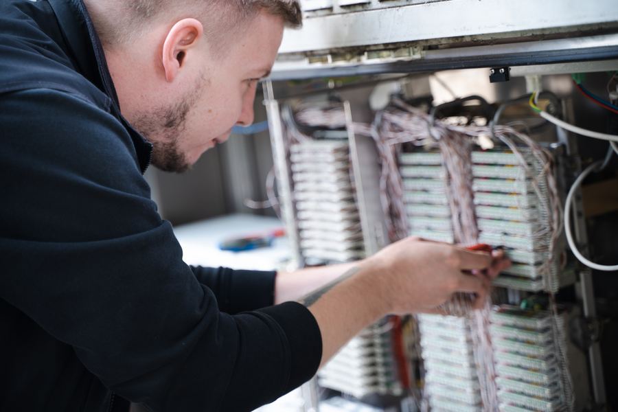 Techniker arbeitet konzentriert am Kabelverzweiger mit aufgelegten Aderpaaren